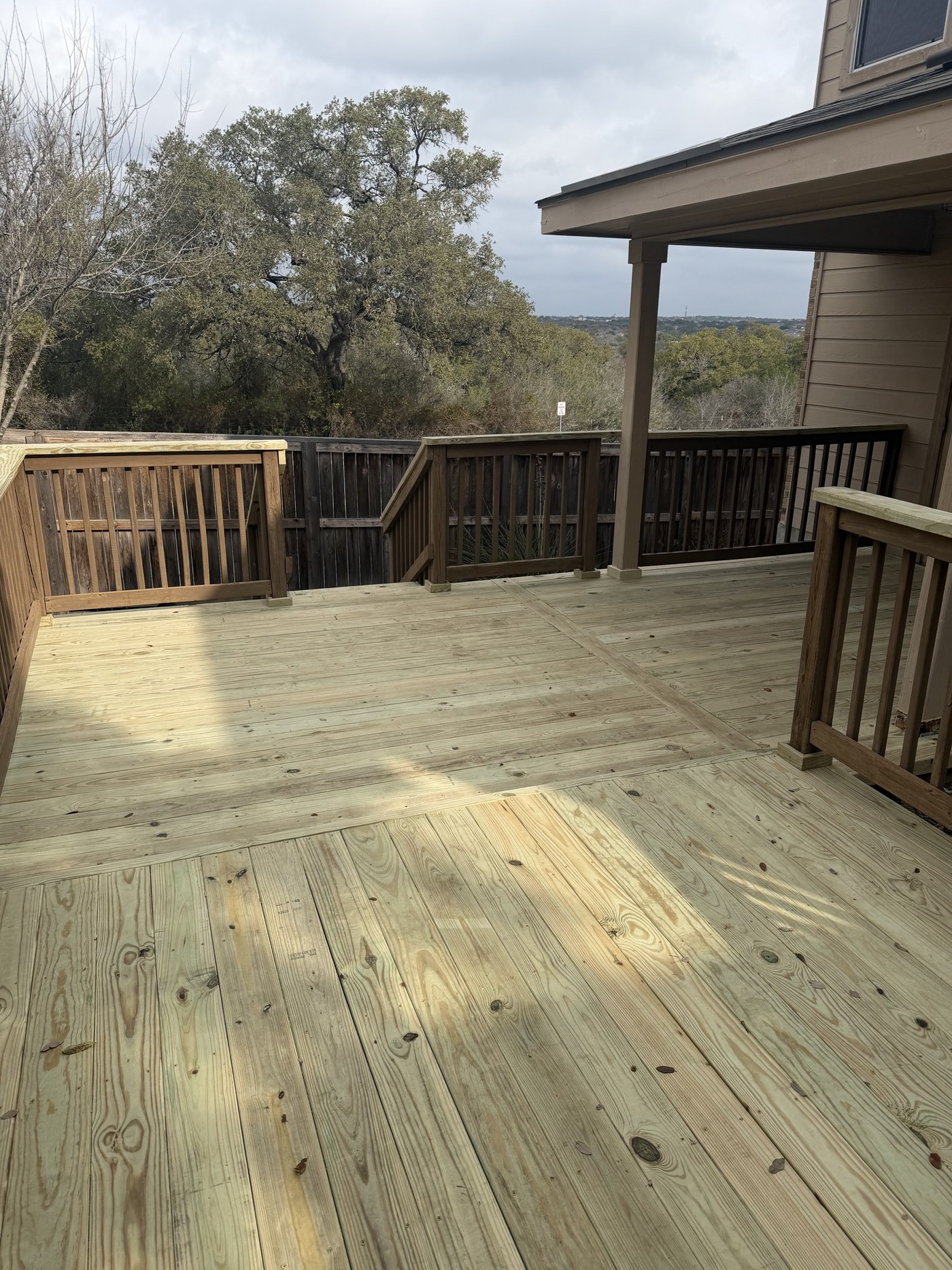 Elevated wood deck with a hill-country tree-line view, San Antonio-area home