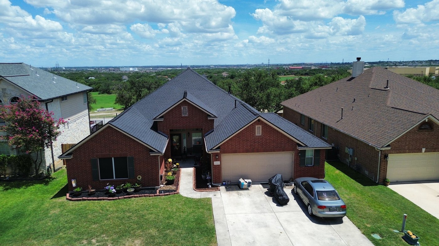 Aerial view of a finished roof replacement, brick home with an elevated view