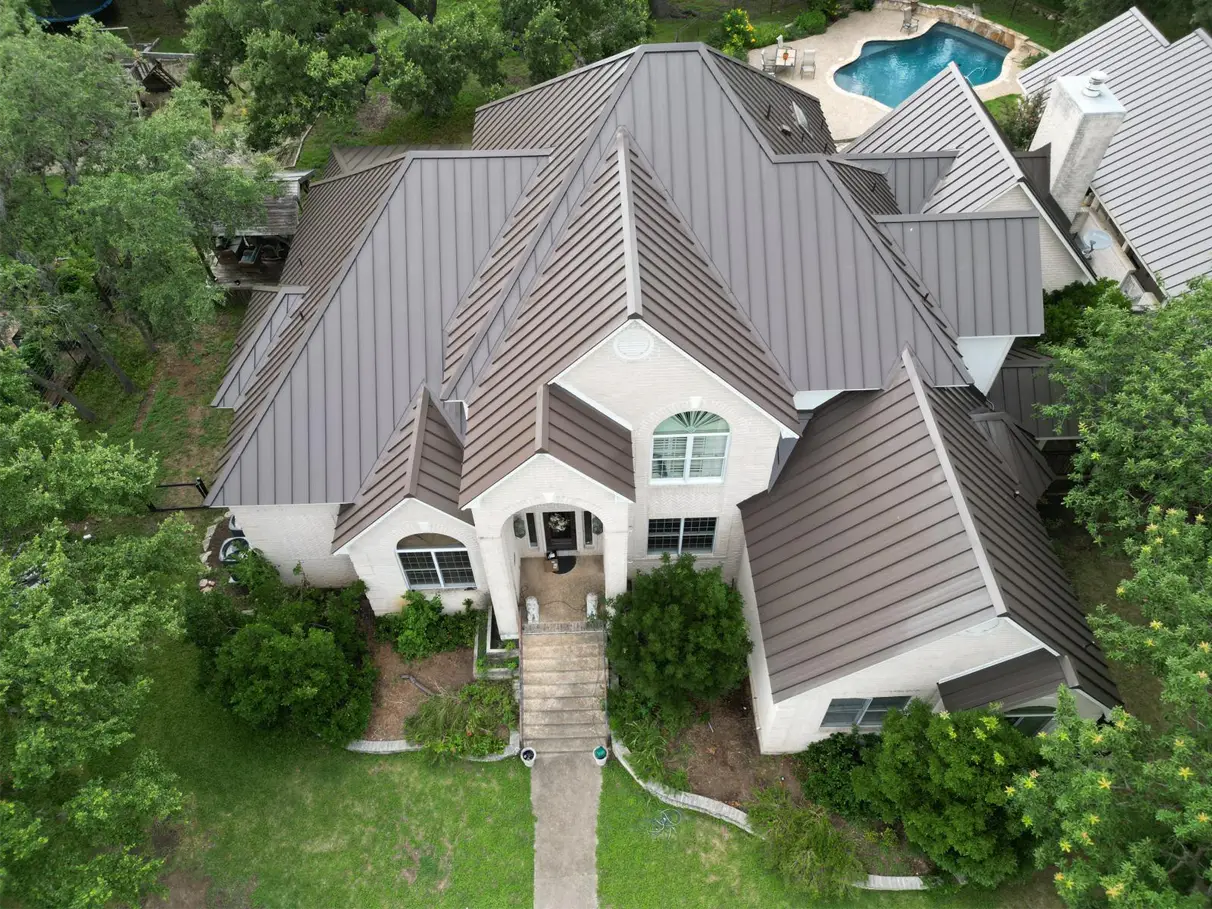 Aerial view of a completed roof, home with a pool