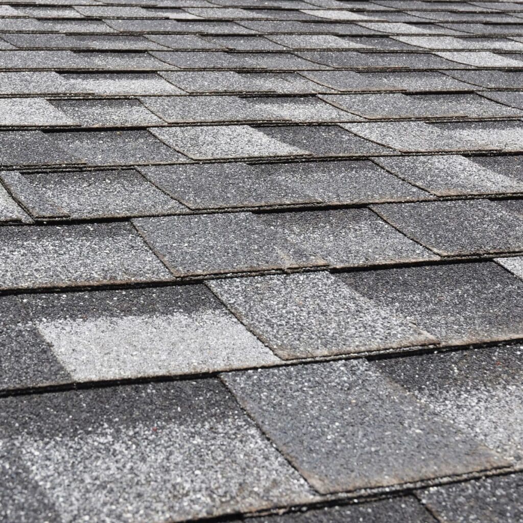 Close-up view of gray asphalt shingles with a textured surface for durability and weather resistance