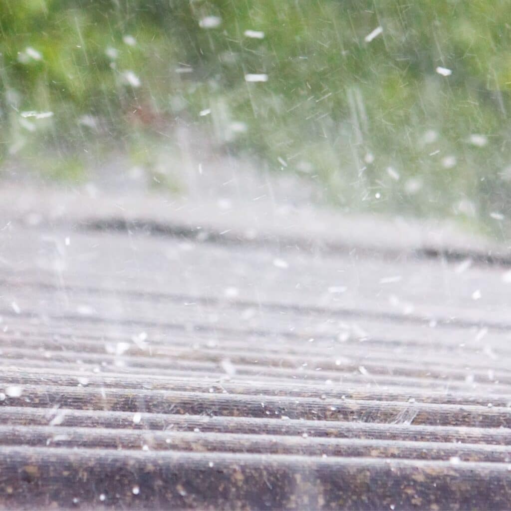 Heavy hailstorm hitting a roof, illustrating severe weather conditions