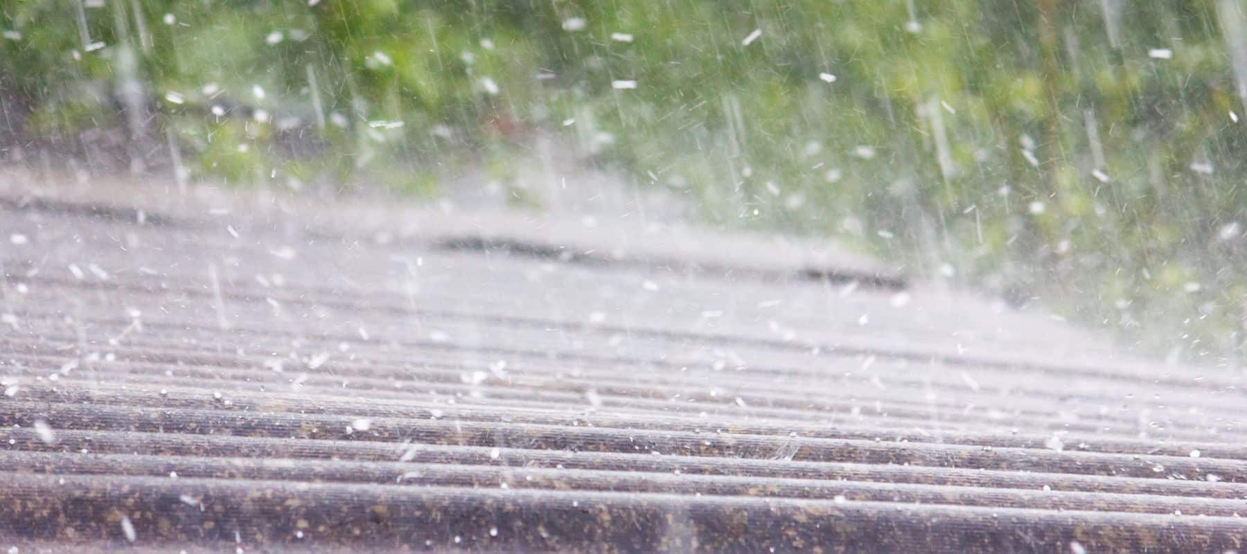 Heavy hailstorm hitting a roof, illustrating severe weather conditions