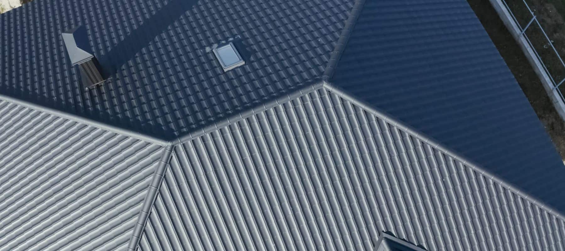 Overhead view of a sleek metal roof with a skylight and chimney, highlighting its contemporary design