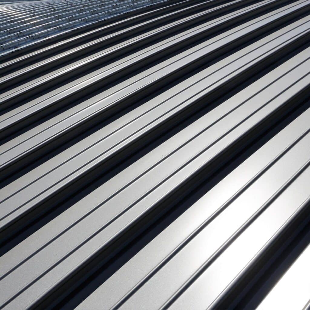 Close-up of a shiny silver metal roof with clean, symmetrical ridges reflecting sunlight