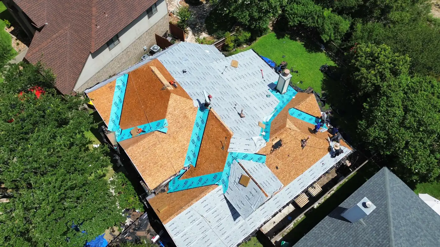 Holmes Roofing crew installing new decking and synthetic underlayment during a roof replacement in Helotes, TX, June 2025
