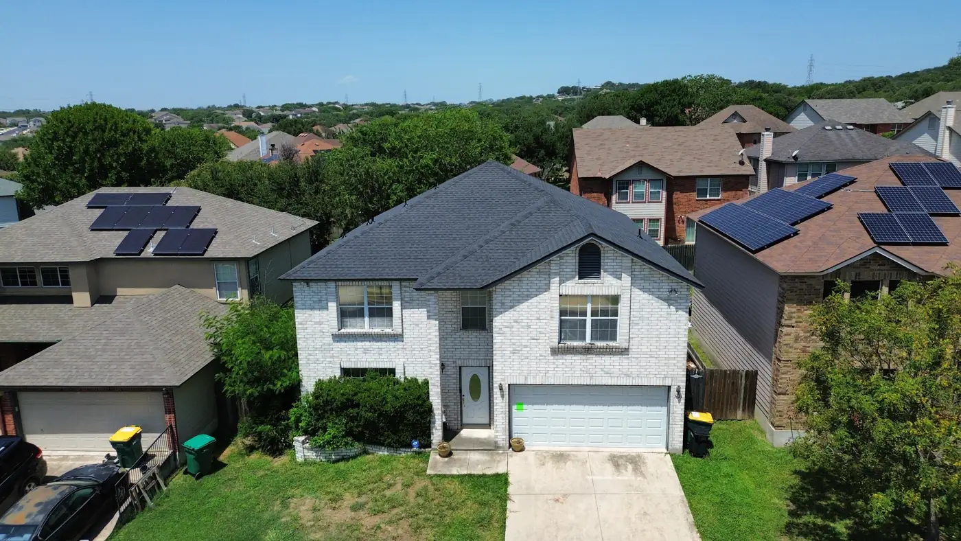 Aerial view of a completed roof replacement on a two-story brick home in Live Oak, TX by Holmes Roofing & Exterior Solutions, July 2025
